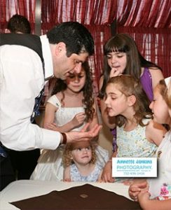 Magician doing trick for young girls